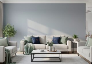Sunlit modern living room featuring a soft gray accent wall with warm white trim, sage-green textiles, navy accents, and blush details.